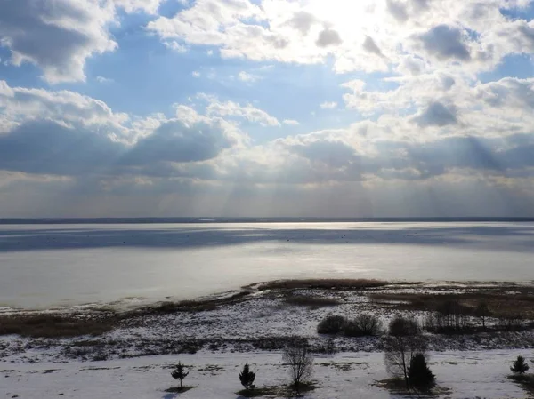 Ghiaccio lago ghiacciato in una giornata invernale soleggiata in Russia. Neve bianca e nuvole nel cielo blu. Bellissimo paesaggio invernale . — Foto Stock