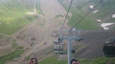 Dağ yamaçlarında teleferikler ve kayak pistleri ile bulutlu bir yaz günü, sis, bulutlar. Siyah piramit Dağı, Krasnaya Polyana, Soçi, Kafkaslar, Rusya.