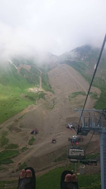 Dağ yamaçlarında teleferikler ve kayak pistleri ile bulutlu bir yaz günü, sis, bulutlar. Siyah piramit Dağı, Krasnaya Polyana, Soçi, Kafkaslar, Rusya.