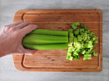 Taze yeşil kereviz, ahşap kesim tahtasının üzerine saplanır..