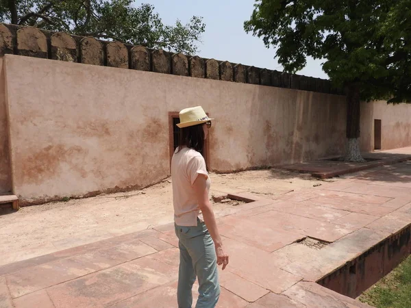 Woman back view, face not visible, admiring the tomb of Itimad-UD-Daul, small Taj Mahal, Agra, India.