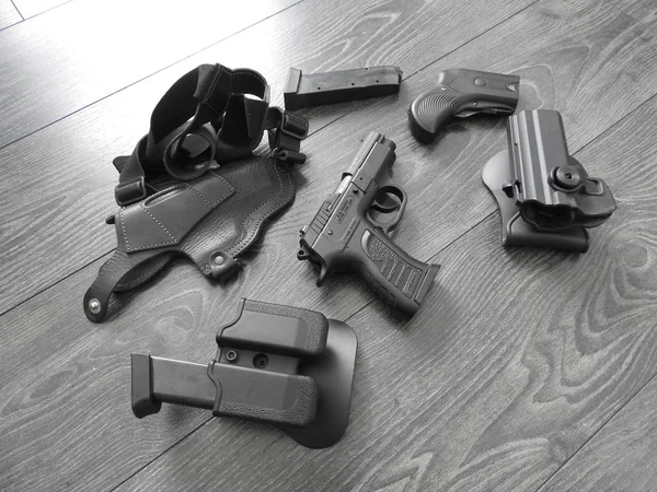 Uma pistola é colocada em cima da mesa com os grampos de magazing . — Fotografia de Stock