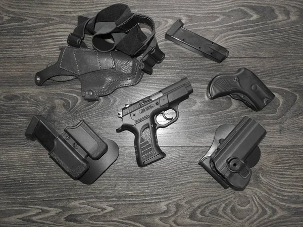 Uma pistola é colocada em cima da mesa com os grampos de magazing . — Fotografia de Stock