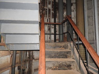 An abandoned prison in an underground bunker. A former Soviet cold war bomb shelter. The sealed door of the bunker. Pipes and valves. Low light condition. Bunker of fear and nightmares.