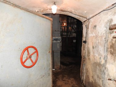 Abandoned prison in underground bunker. Ghost of prisoner. Ex Soviet cold war bomb shelter. Hermetic doors of bunker. Pipes and valves. Low light condition. Bunker of fear and nightmares.