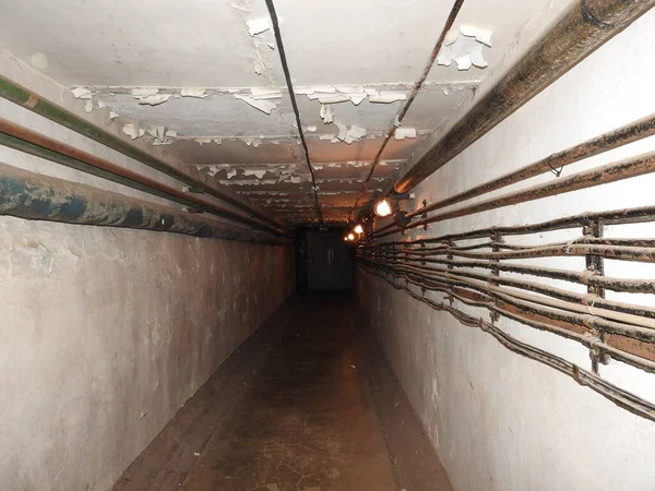 Övergiven fängelse i underjordisk bunker. Fångens ande. Före detta sovjetiskt skyddsrum för kalla kriget. Hermetiska dörrar i bunkern. Rör och ventiler. Lågt ljustillstånd. Bunker av rädsla och mardrömmar. — Stockfoto