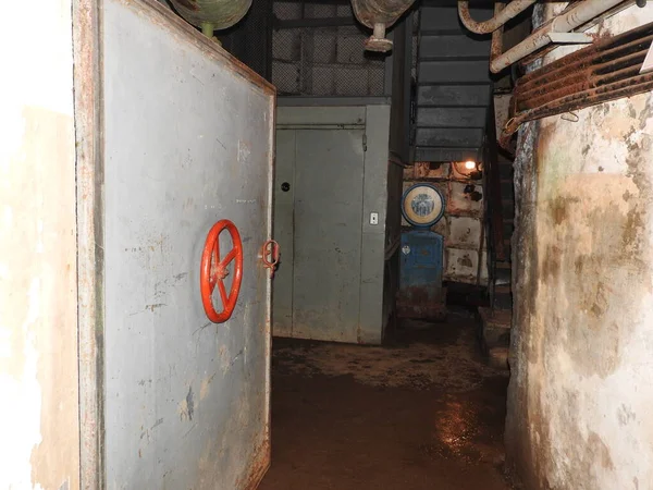 Prigione abbandonata nel bunker sotterraneo. Fantasma del prigioniero. Ex rifugio antiatomico sovietico. Porte ermetiche del bunker. Tubi e valvole. Condizioni di scarsa illuminazione. Bunker di paura e incubi . — Foto Stock