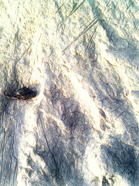 Malý černý kámen na písku. Nerovný povrch pláže je broušen hladkými pruhy a krátery roztrhané formy. Výtvarně strukturovat kresbu. Výtvarné kreslení bělicí styl plátna. — Stock fotografie