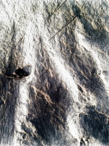 Uma pequena pedra negra na areia. A superfície irregular da praia é cortada por listras lisas e crateras de forma rasgada. Textura desenho artístico. Arte desenhar estilo de lona fotográfica . — Fotografia de Stock