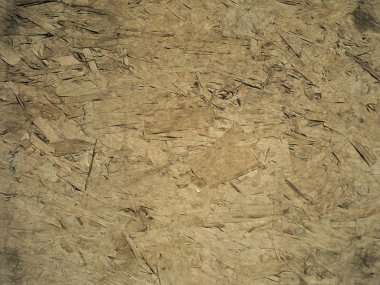 Bir levha ahşap yonga tahtası yakın. Talaşlar kaotik bir şekilde birbirlerine yapıştırılmış ve üst üste. Doku sanatsal çizim. Sanat Beraberlik kremsi sarı tarzı.