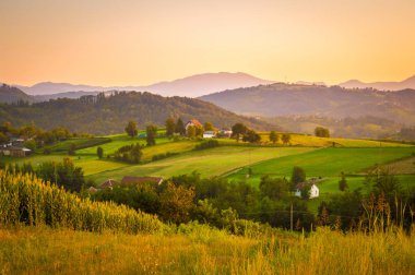 Büyük panorama manzara dağ köyü. Sırbistan, Europe. Tepeler ve vadiler yaz akşam. Çayırlar ve tarım arazisi.
