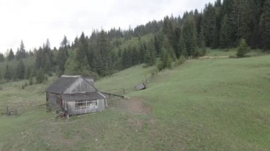 Dağlarda bir ev. Ağır çekim. Karpatlar. Ukrayna. Havadan. Gri, düz