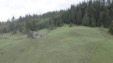 Dağlarda bir ev. Ağır çekim. Karpatlar. Ukrayna. Havadan. Gri, düz