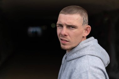 Kapüşonlu spor ceketli bir kabadayı.