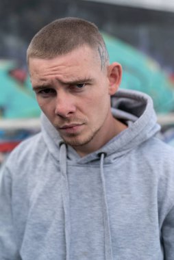 Kapüşonlu spor ceketli bir kabadayı.