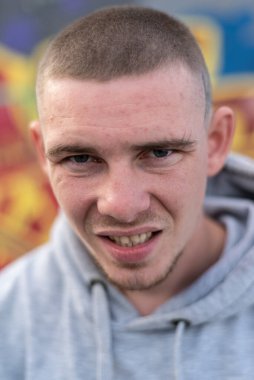 Kapüşonlu spor ceketli bir kabadayı.