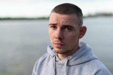 Kapüşonlu spor ceketli bir kabadayı.