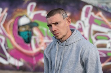 Kapüşonlu spor ceketli bir kabadayı.