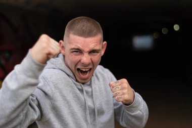 Kapüşonlu spor ceketli bir kabadayı.