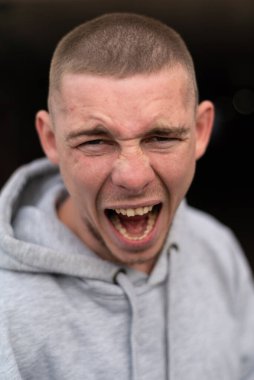 Kapüşonlu spor ceketli bir kabadayı.