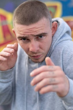 Kapüşonlu spor ceketli bir kabadayı.