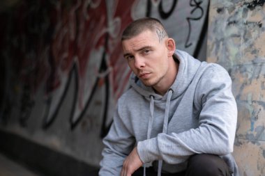 Kapüşonlu spor ceketli bir kabadayı.