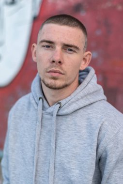 Kapüşonlu spor ceketli bir kabadayı.