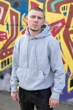 Kapüşonlu spor ceketli bir kabadayı.