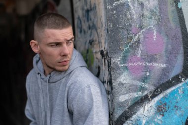 Kapüşonlu spor ceketli bir kabadayı.