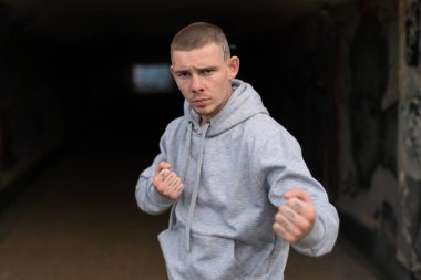 Kapüşonlu spor ceketli bir kabadayı.