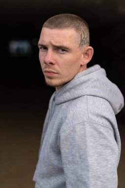 Kapüşonlu spor ceketli bir kabadayı.