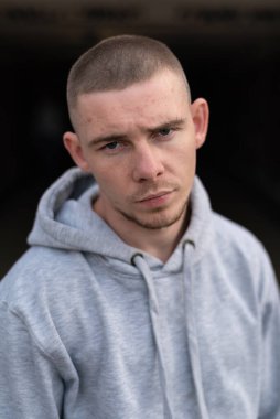 Kapüşonlu spor ceketli bir kabadayı.