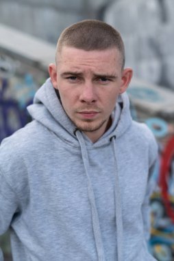 Kapüşonlu spor ceketli bir kabadayı.