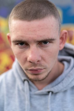 Kapüşonlu spor ceketli bir kabadayı.