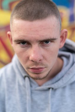 Kapüşonlu spor ceketli bir kabadayı.