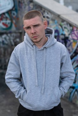 Kapüşonlu spor ceketli bir kabadayı.