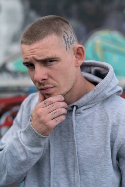 Kapüşonlu spor ceketli bir kabadayı.