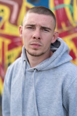 Kapüşonlu spor ceketli bir kabadayı.