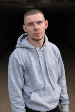 Kapüşonlu spor ceketli bir kabadayı.