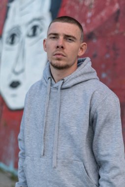 Kapüşonlu spor ceketli bir kabadayı.