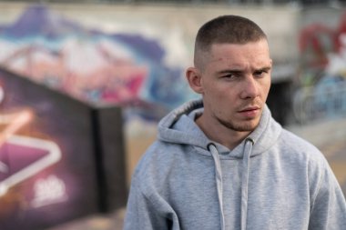 Kapüşonlu spor ceketli bir kabadayı.