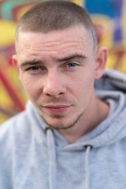 Kapüşonlu spor ceketli bir kabadayı.