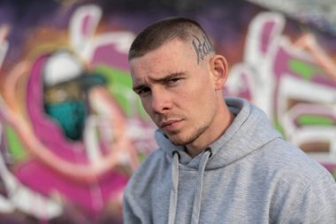 Kapüşonlu spor ceketli bir kabadayı.