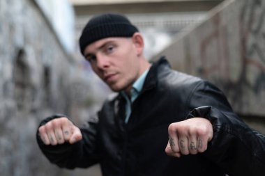 Kabadayı bir adamın kolunda ACAB dövmesi var.