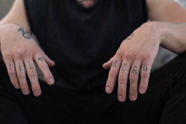 Kabadayı bir adamın kolunda ACAB dövmesi var.