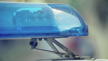 Polis teşhircisi devriye arabasının çatısında yanıp sönüyor.