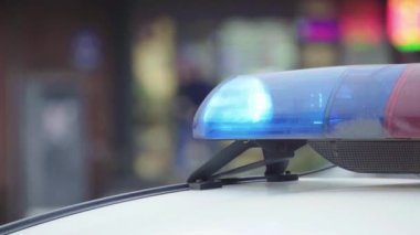 Polis teşhircisi devriye arabasının çatısında yanıp sönüyor.