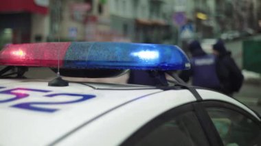 Polis teşhircisi devriye arabasının çatısında yanıp sönüyor.