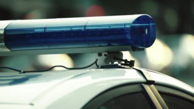 Polis teşhircisi devriye arabasının çatısında yanıp sönüyor.