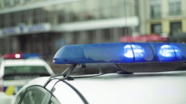 Polis teşhircisi devriye arabasının çatısında yanıp sönüyor.